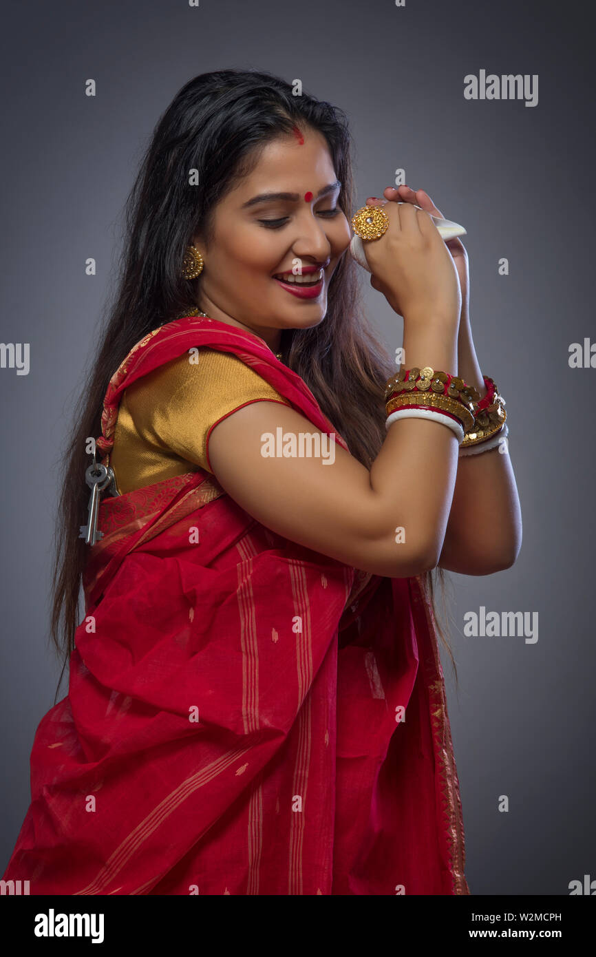 Portrait of a beautiful Bengali woman holding conch shell Stock Photo
