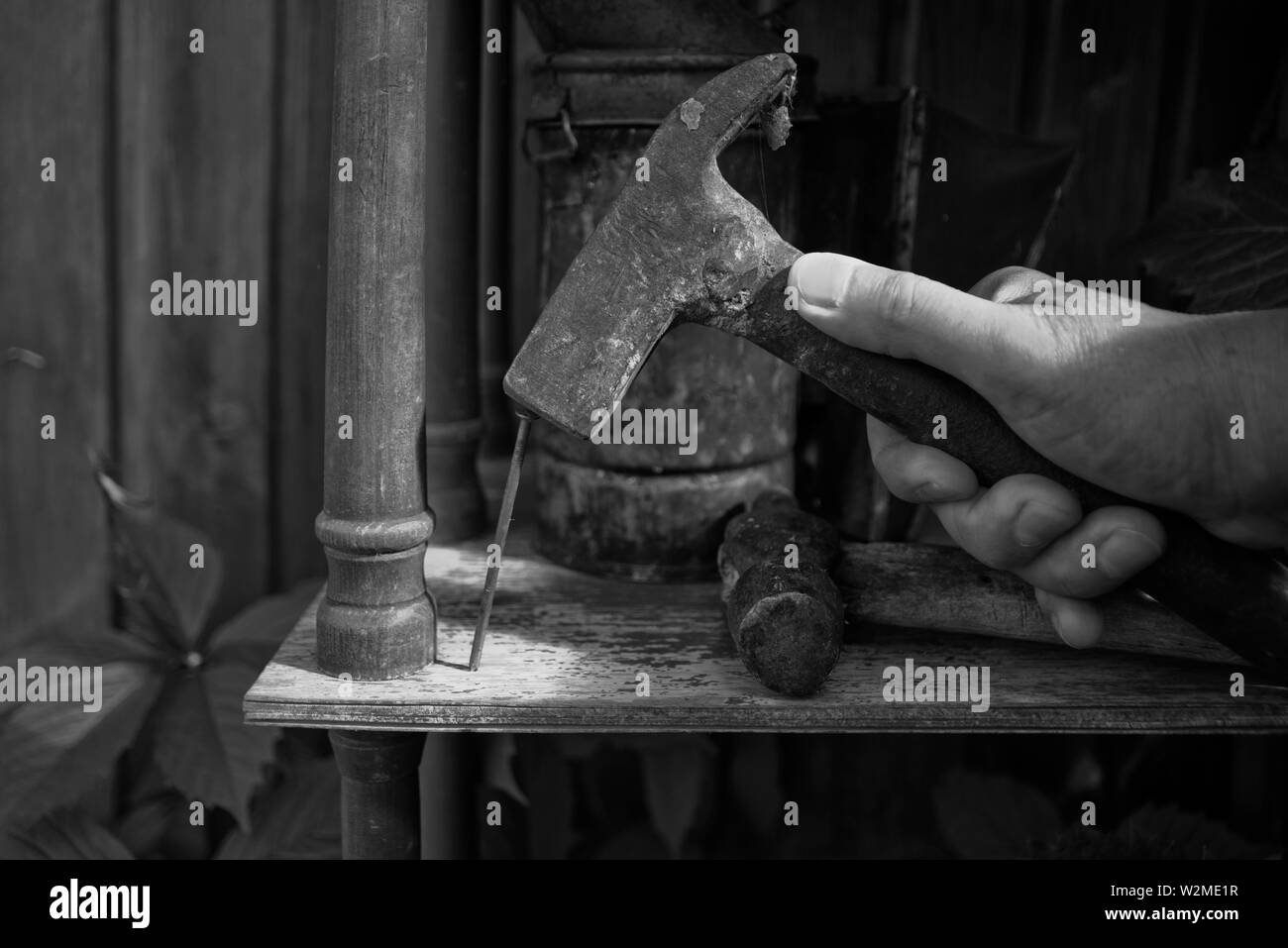 Black and white image of a hand and hammer in nails Stock Photo - Alamy