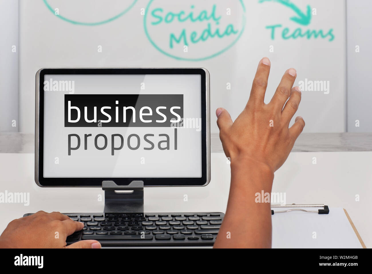 A mans hand being raised to ask a question while working on a business proposal in a business meeting. Stock Photo