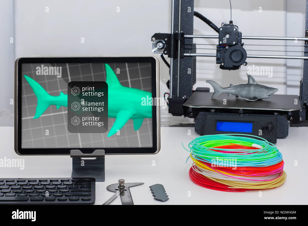 A wireless 3d printer setup using a tablet monitor, keyboard and 3d printing filament and machine. Stock Photo