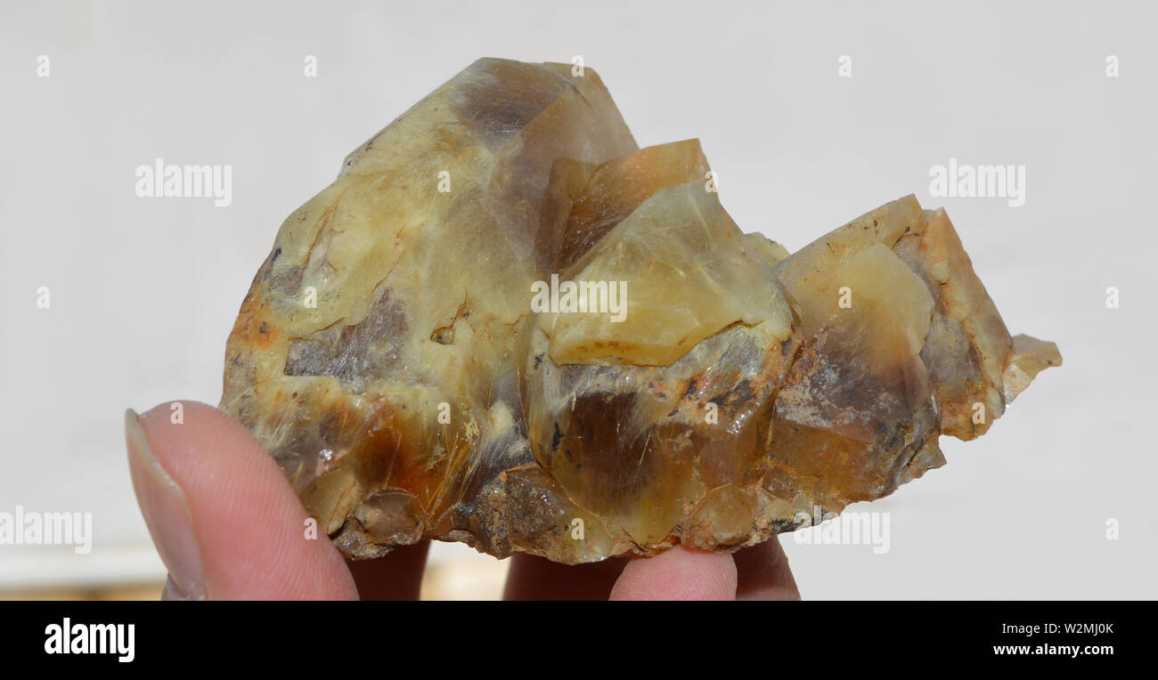 Yellow Quartz specimen with golden rutile inclusion, hand holded, origin Pakistan. Stock Photo