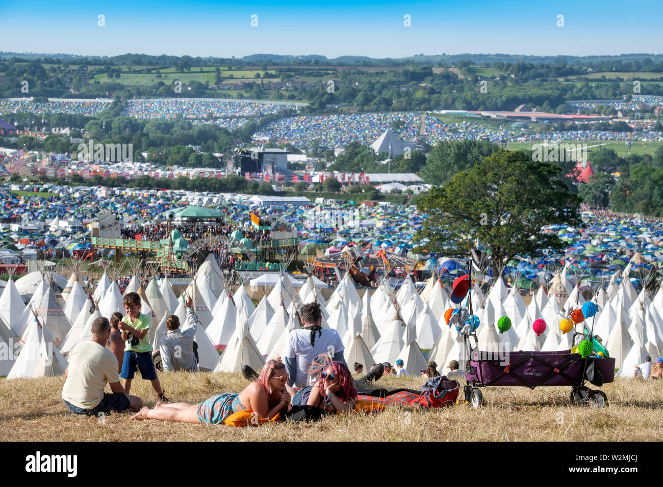 A festival going family relax above the Tipi Village at Glastonbury 2019 Stock Photo