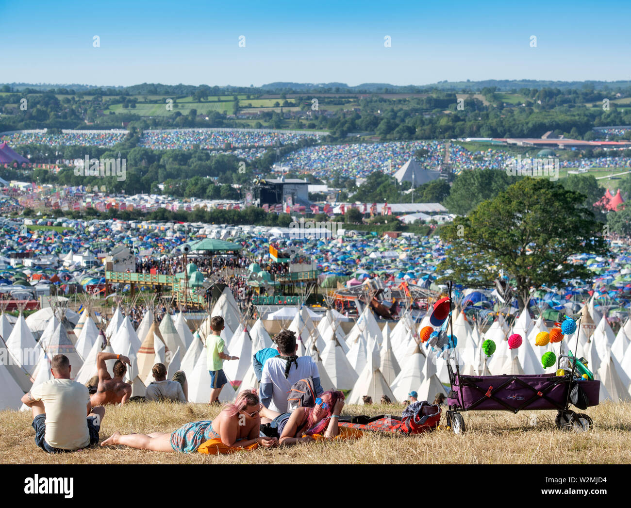 A festival going family relax above the Tipi Village at Glastonbury 2019 Stock Photo