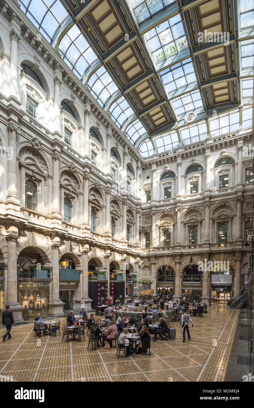 The beautiful Royal Exchange courtyard, in the heart of the City of London - busy with shoppers and dinners enjoying the luxury shopping center. Stock Photo