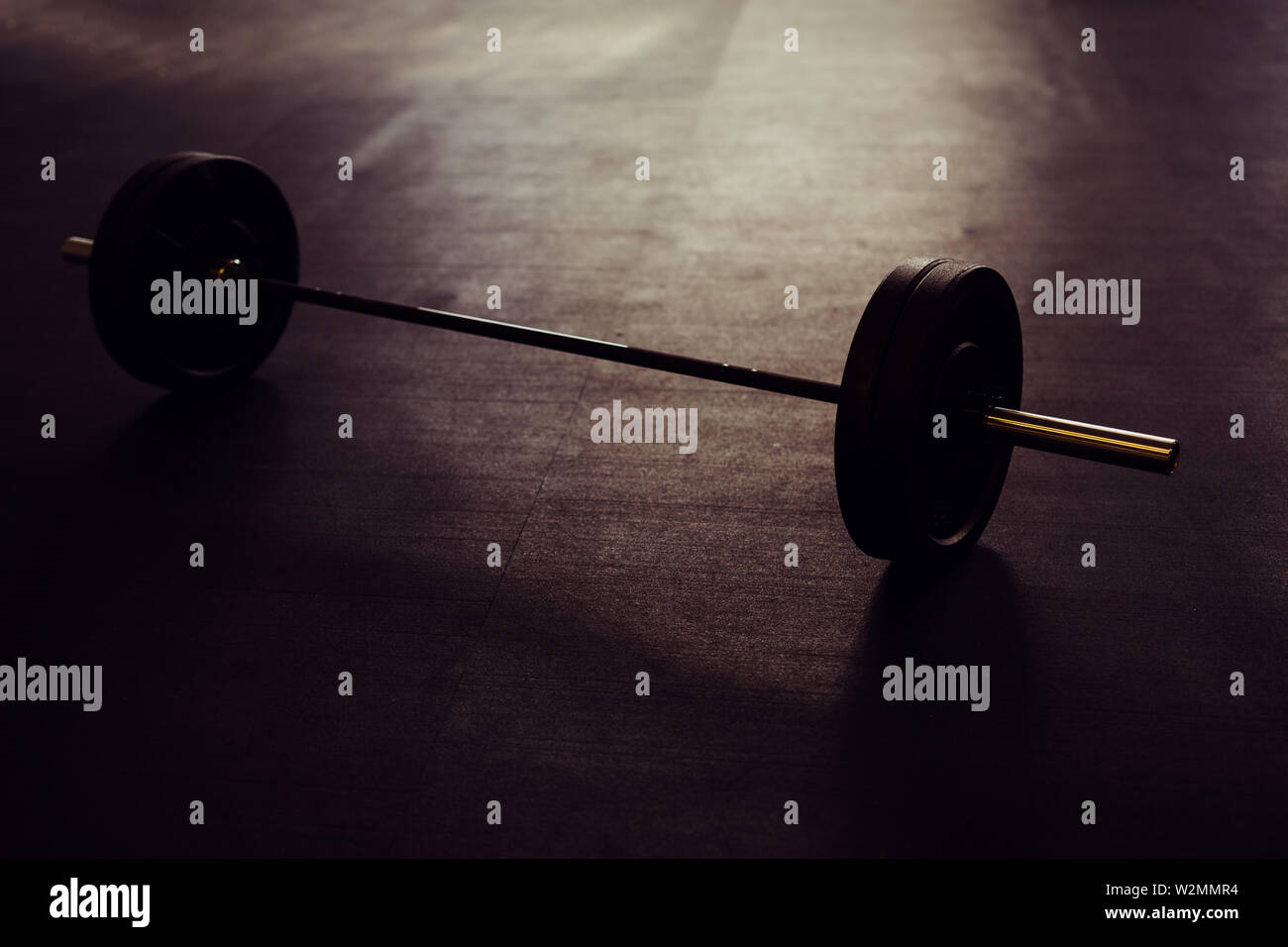 Concept shot of barbell lying on floor in industrial setting Stock Photo