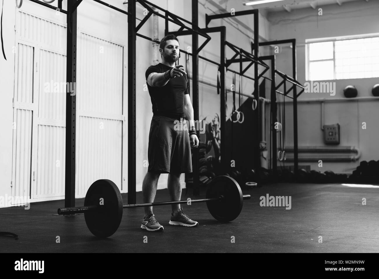 Handsome athlete pointing and looking away while between weightlifting sessions Stock Photo