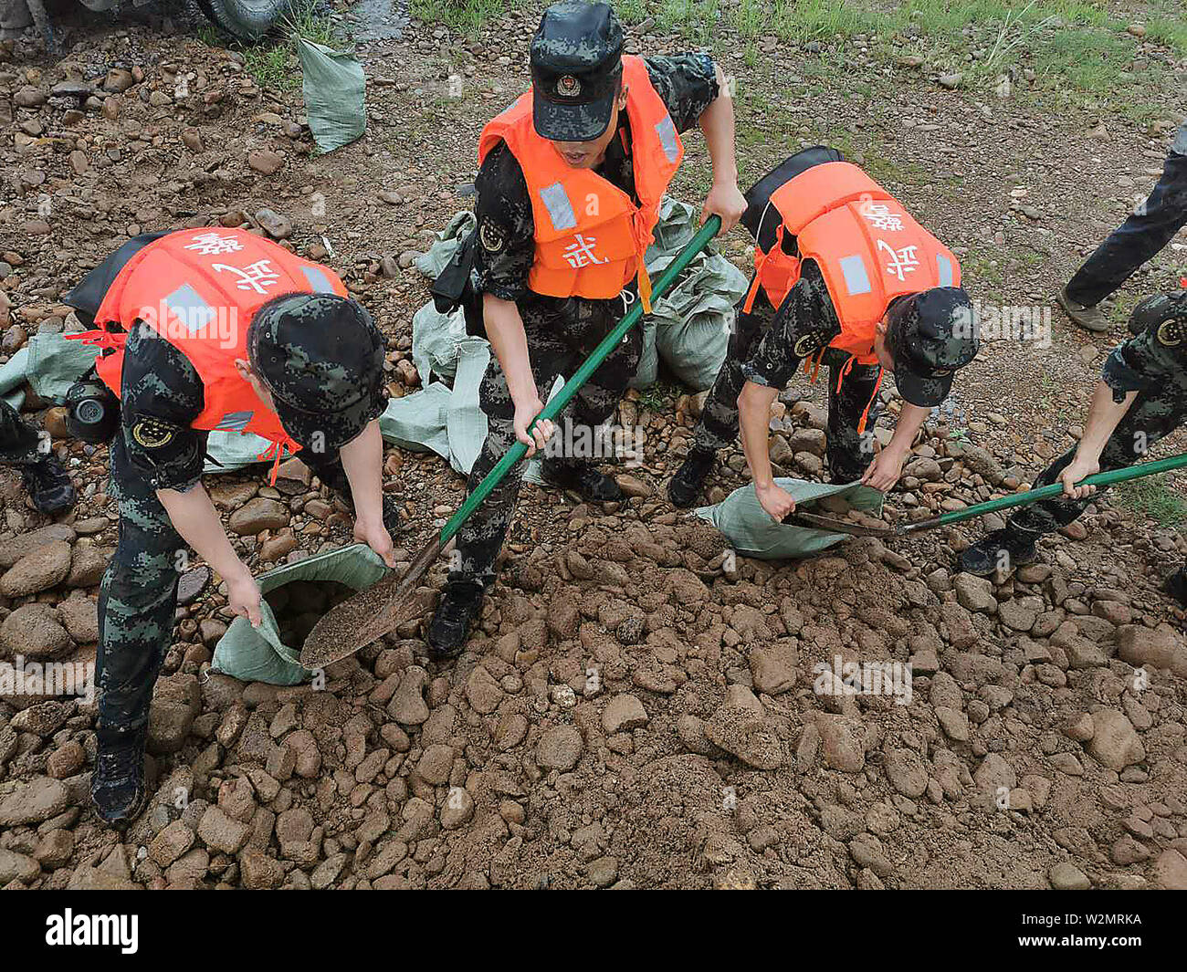 (190710) -- YINGTAN, July 10, 2019 (Xinhua) -- Rescuers fill in sandbags against the flood at the site of the collapsed Maquan Dyke at Maquan Township in Yingtan, east China's Jiangxi Province, July 9, 2019. The Maquan Dyke in Maquan Township collapsed due to heavy rainstorms on Tuesday. (Photo by Wang Bin/Xinhua) Stock Photo