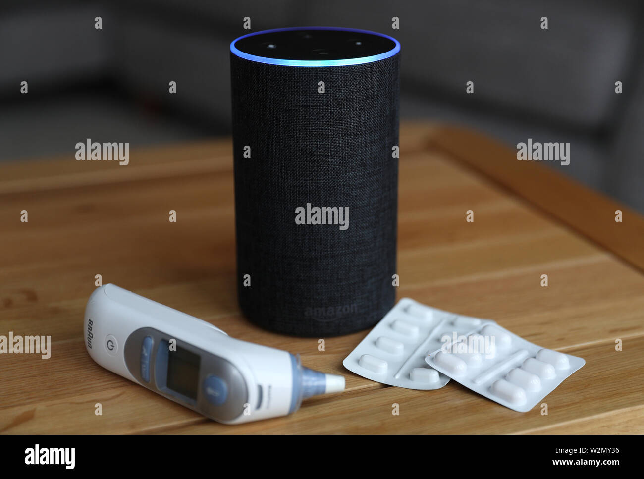 A general view of an Amazon Echo smart speaker alongside an ear thermometer  and some pills. Amazon's Alexa is set to answer people's health queries by  searching the official NHS website Stock