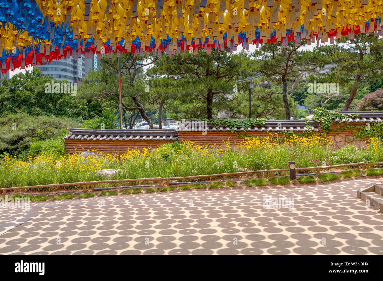 Colorful lanterns and picturesque pine trees during day time at the Bongeunsa buddhist temple, Seoul, South Korea Stock Photo