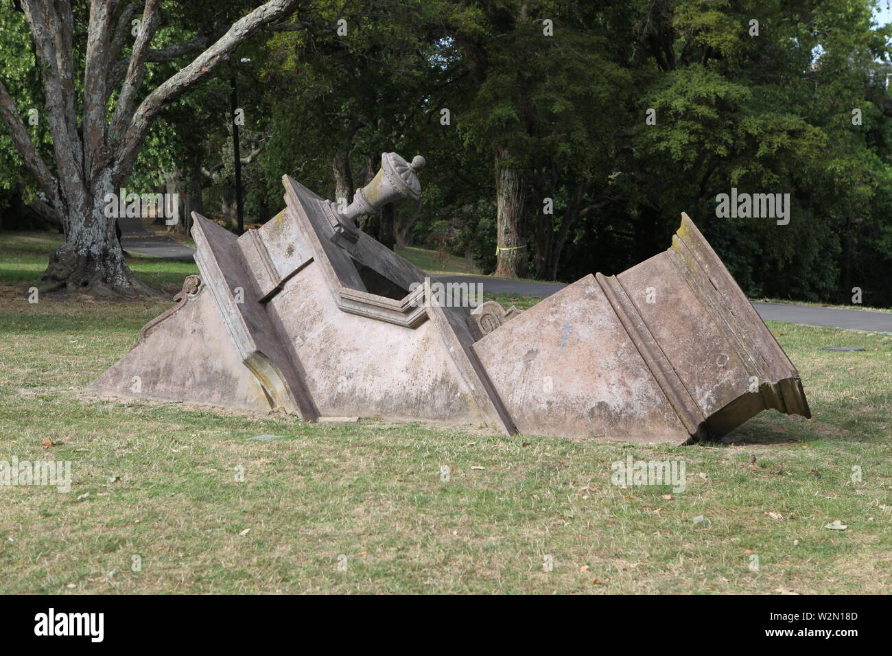 Bit of old 19th century tower growing from grass in a park in Auckland, New Zealand Stock Photo