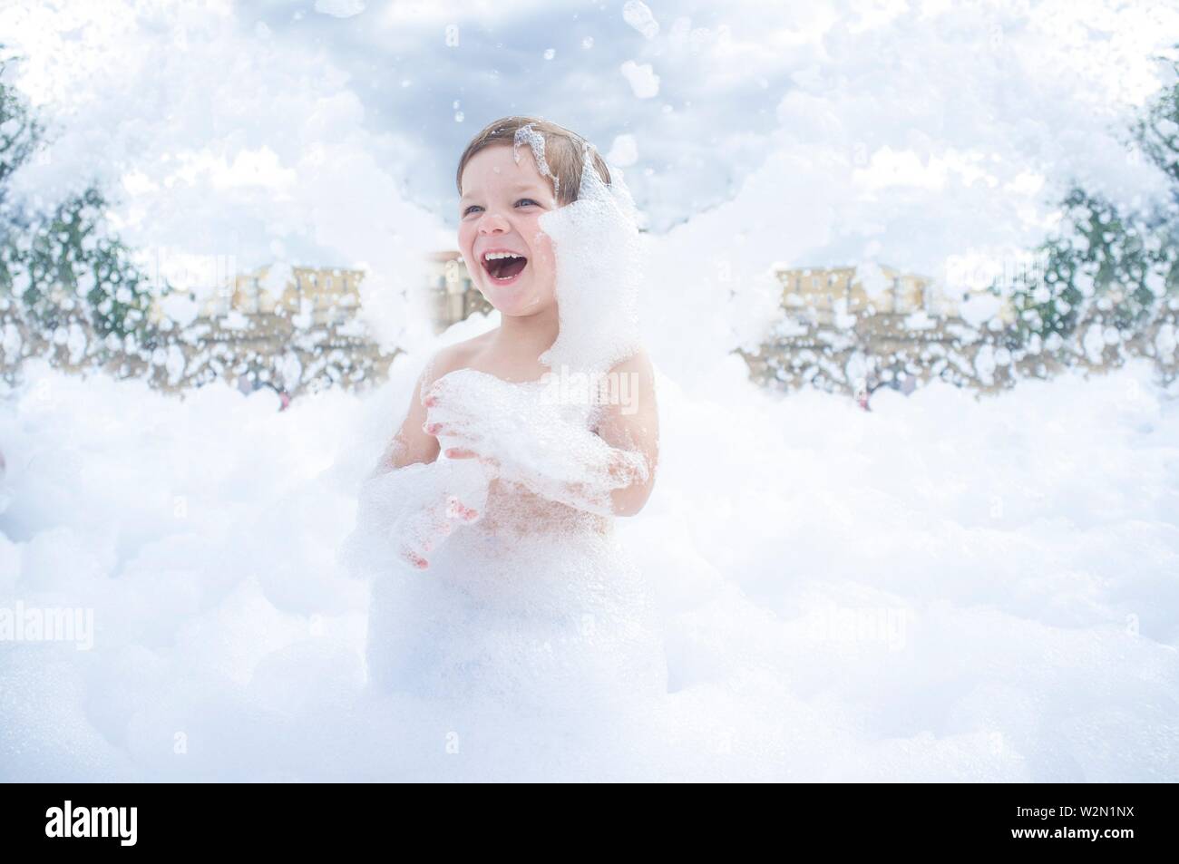 3 years boy enjoying at foam party outdoors. Active leisure on summer season for children. Stock Photo