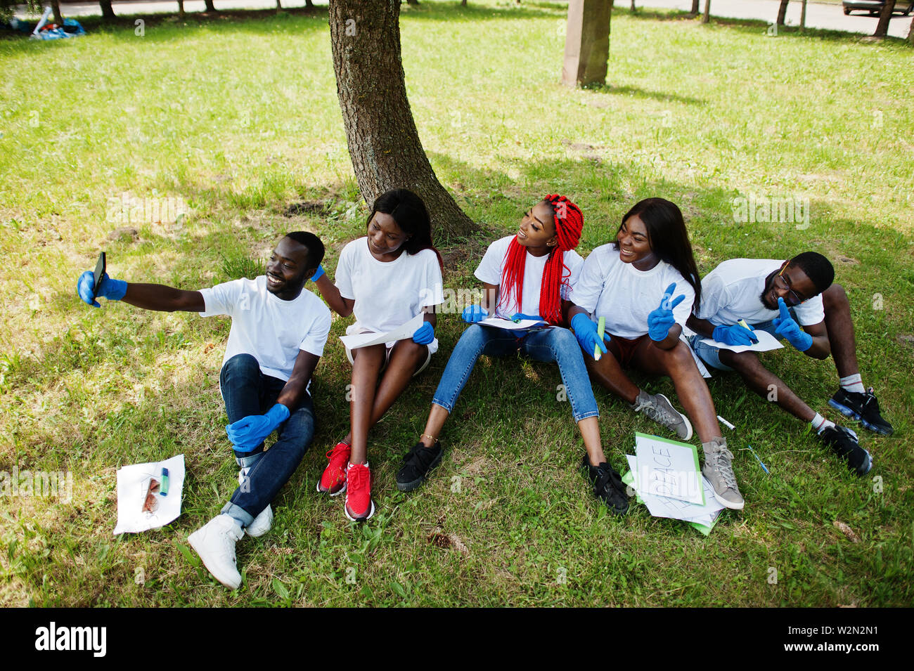 Group people sitting under tree hi-res stock photography and images - Alamy