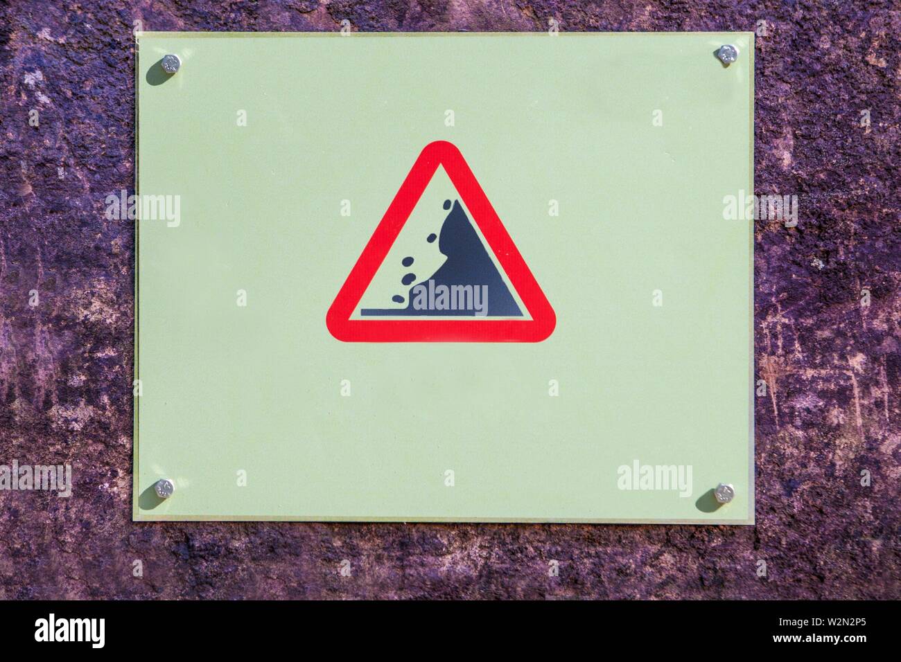 Landslide Caution falling rocks sign attached to the rock, Malaga, Spain. Stock Photo