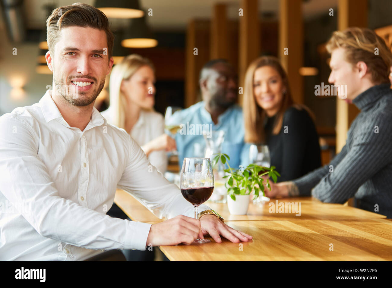 Young man with a glass of red wine for relaxation in the restaurant Stock Photo