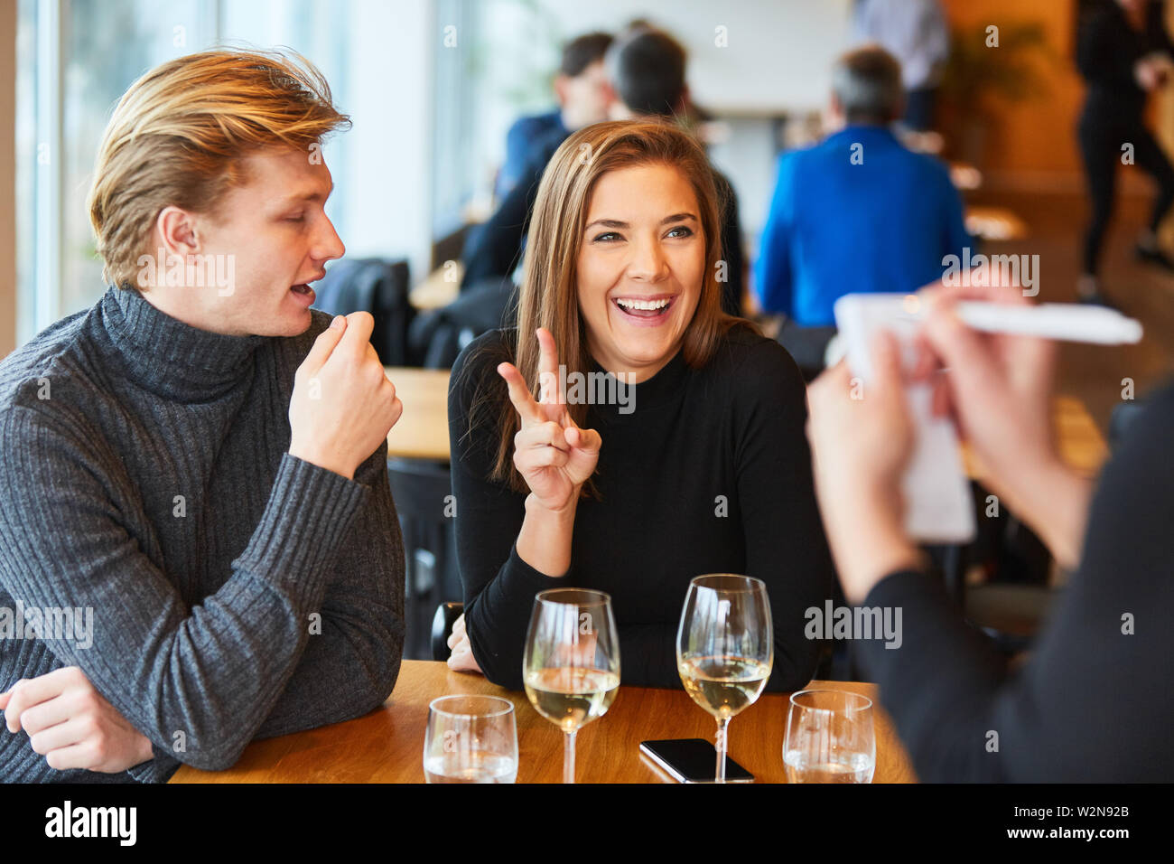 Young couple in the bistro or restaurant ordered food from waiter or waitress Stock Photo