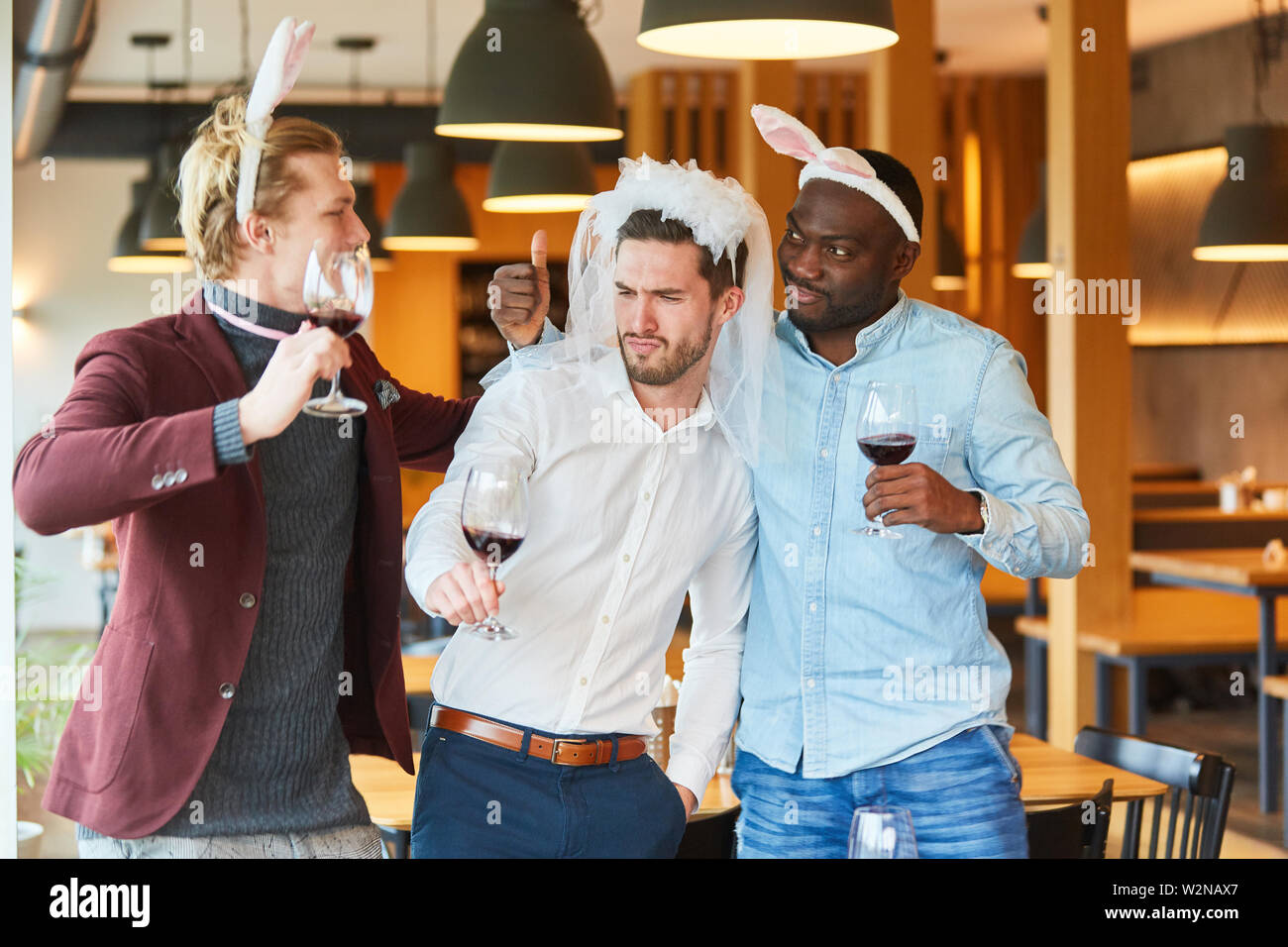 Three friends celebrate drunken bachelor party together and silly around Stock Photo