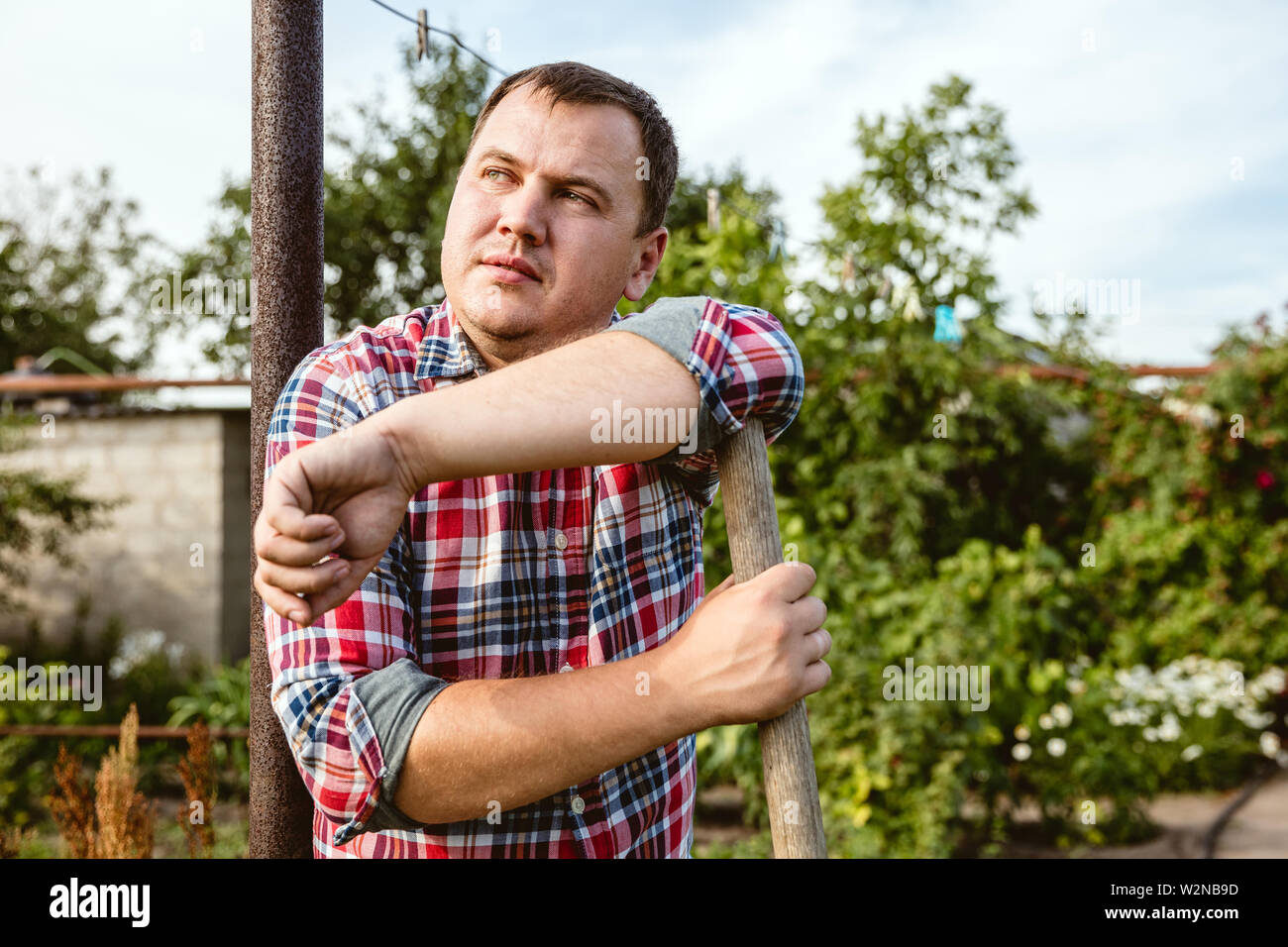 Young farmer working at his garden in sunny day. Man engaged in the ...