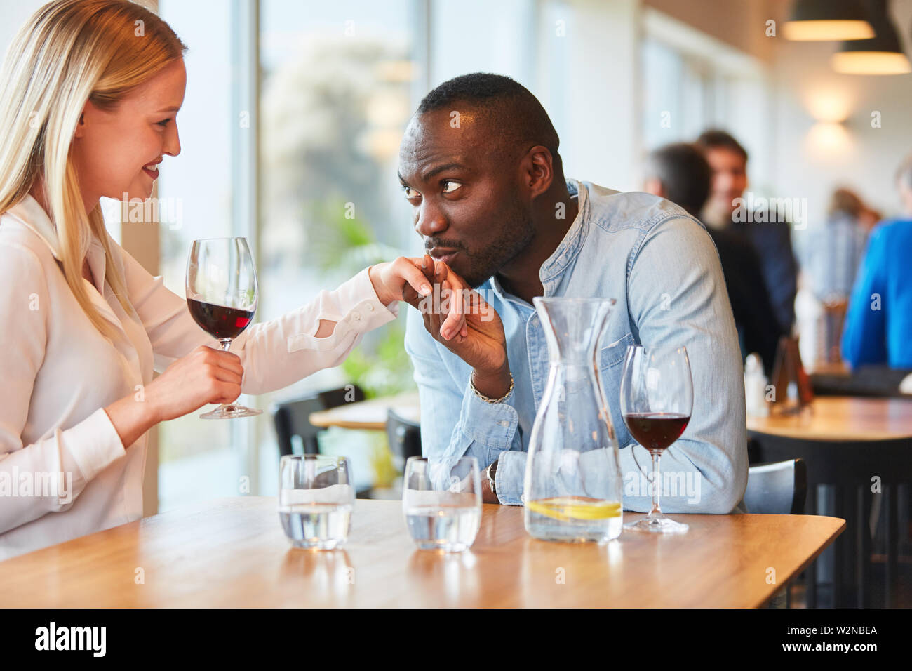 African man on date in the restaurant while flirting with his girlfriend Stock Photo