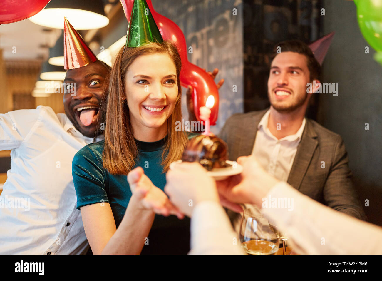Woman as birthday girl gets cake given at her birthday party Stock Photo Alamy