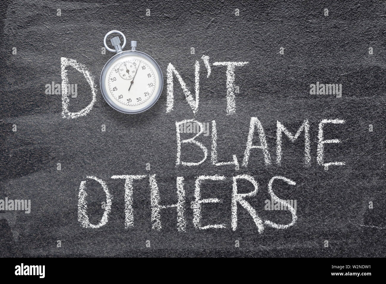 don’t blame others phrase handwritten on chalkboard with vintage precise stopwatch used instead of O Stock Photo