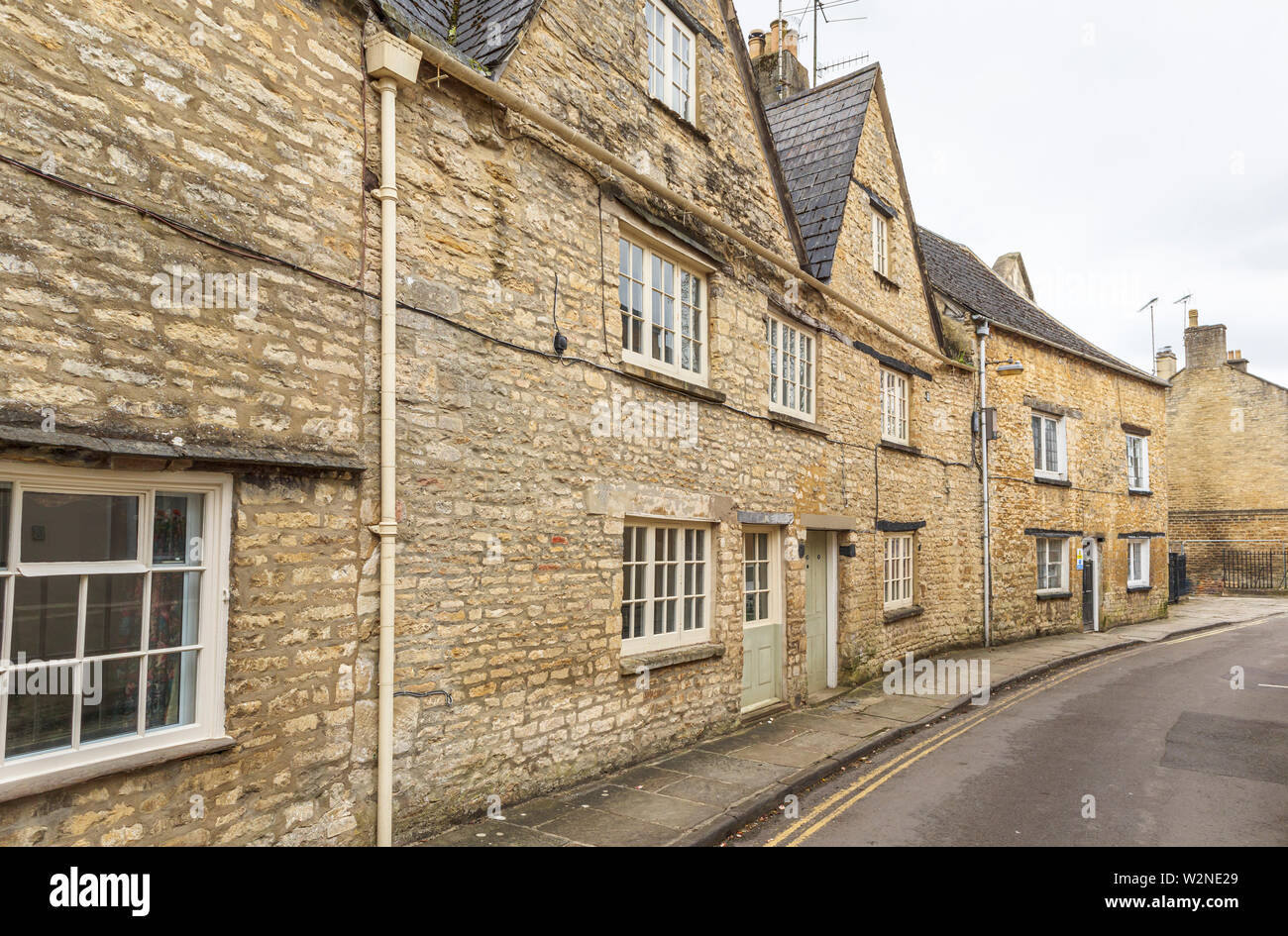 Street view of a row of traditional Cotswold stone cottages in