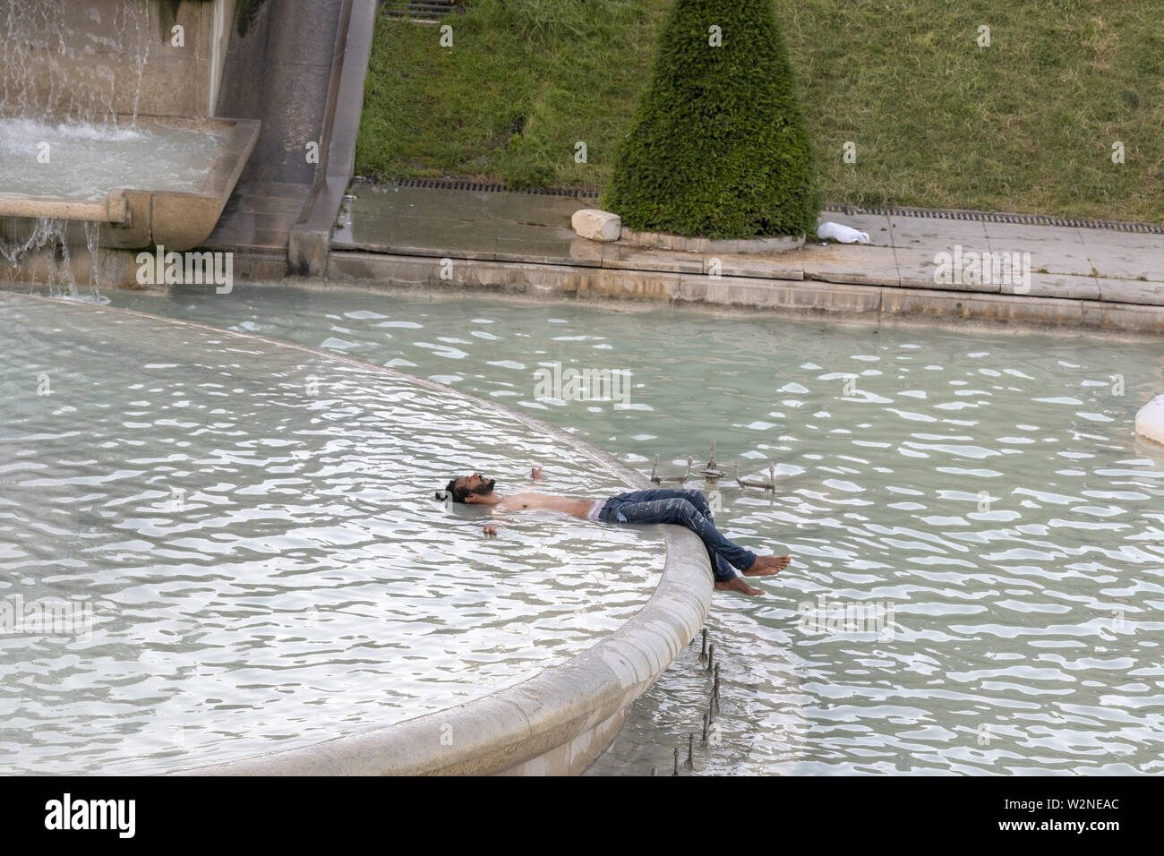 Europe, France, Paris, 2019-06, The Trocadero gardins a popular touristic attraction facing the Eiffel Tower shows people bathing in the fountains in Stock Photo