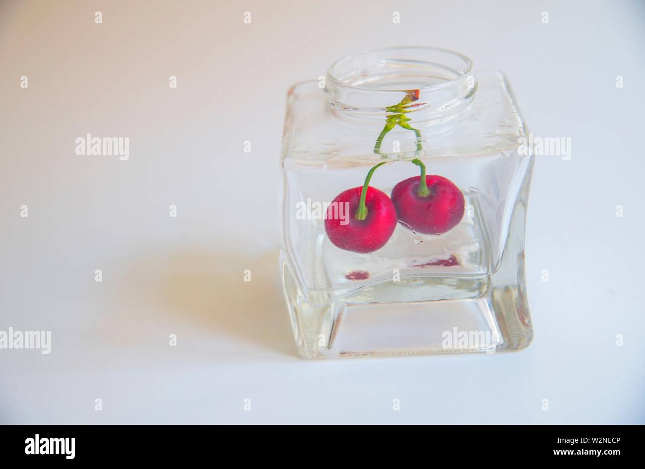 Two cherries in a glass jar Stock Photo Alamy