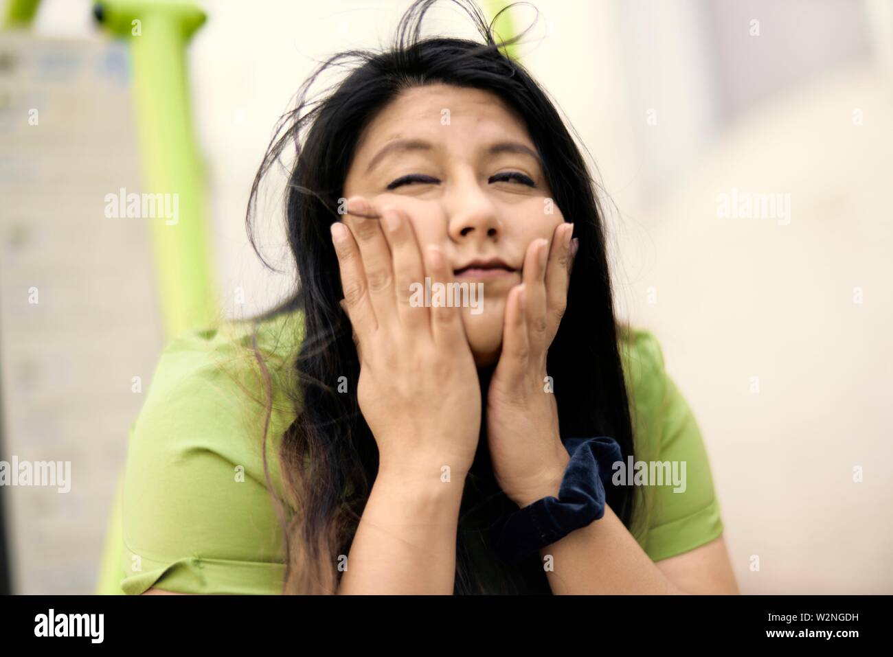 bemused woman rubbing cheeks with hands Stock Photo Alamy