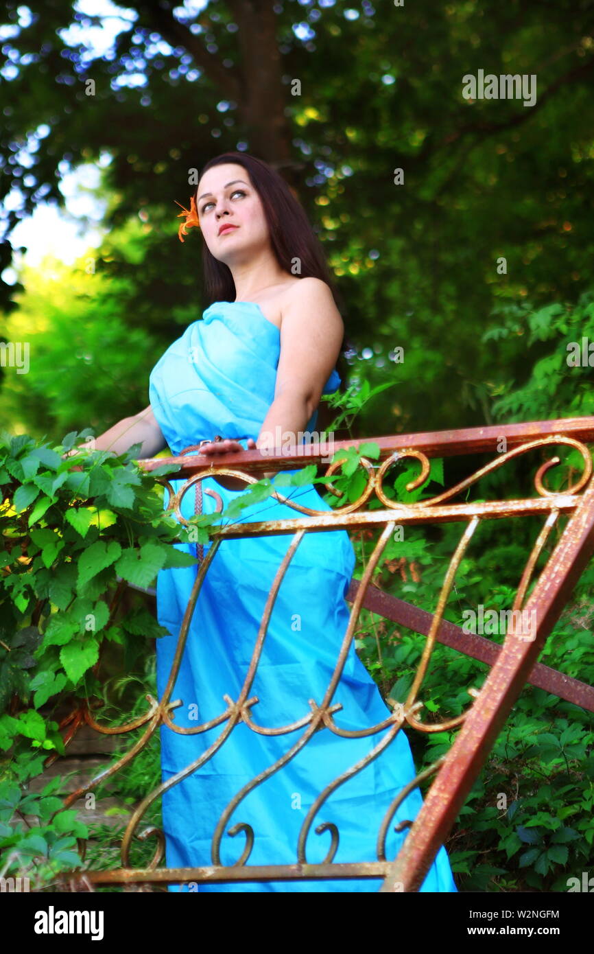 Beautiful girl in a blue dress in the park Stock Photo - Alamy