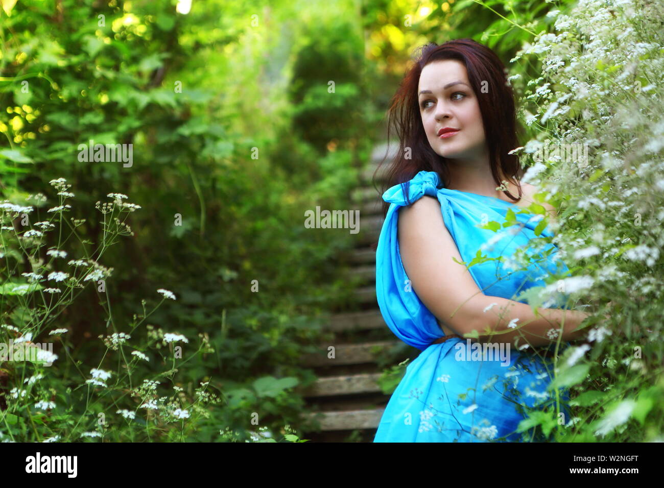 Beautiful girl in a blue dress in the park Stock Photo - Alamy