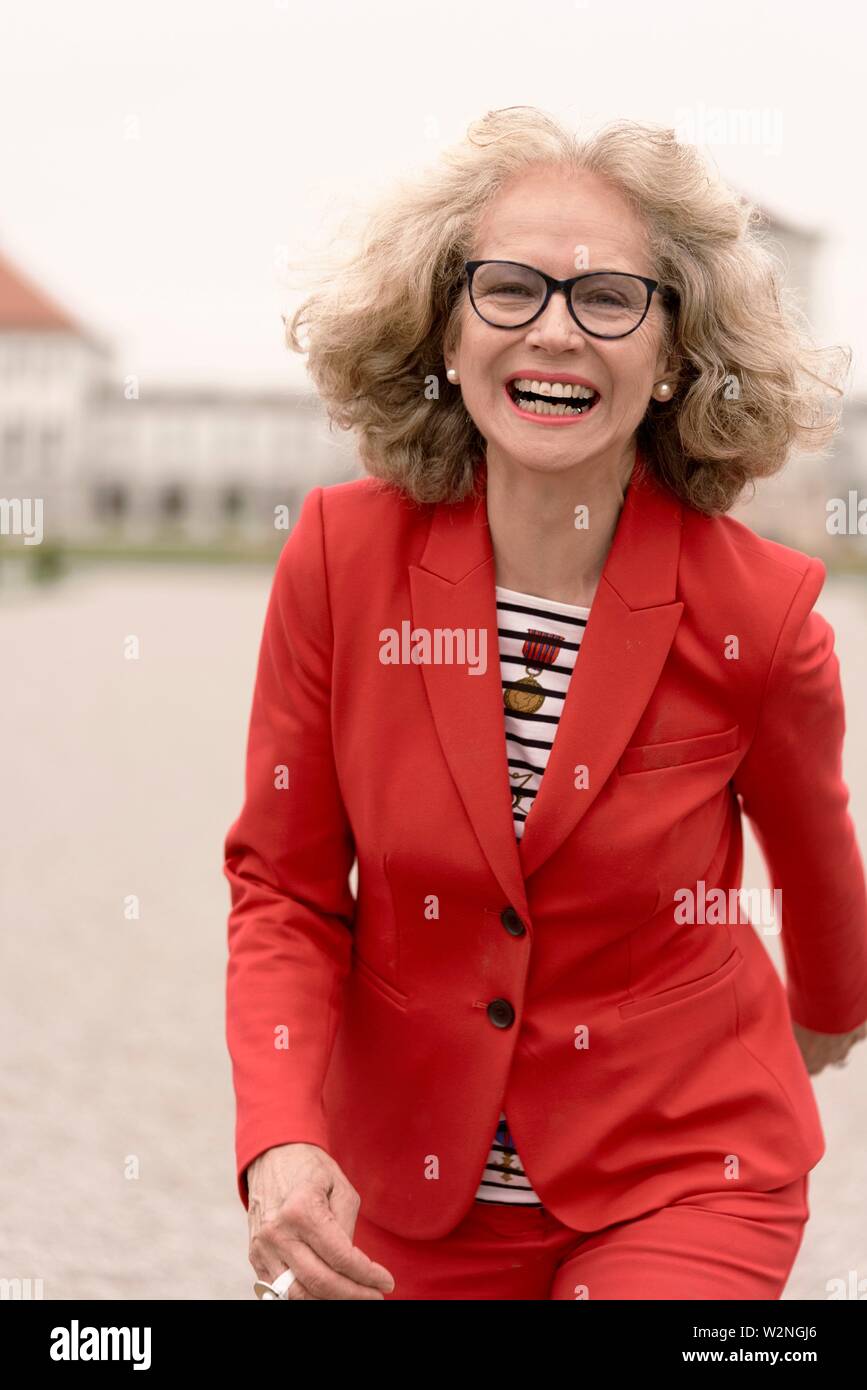 vibrant senior woman (67 years old) running outdoors in city, in  Nymphenburg, Munich, Germany Stock Photo - Alamy