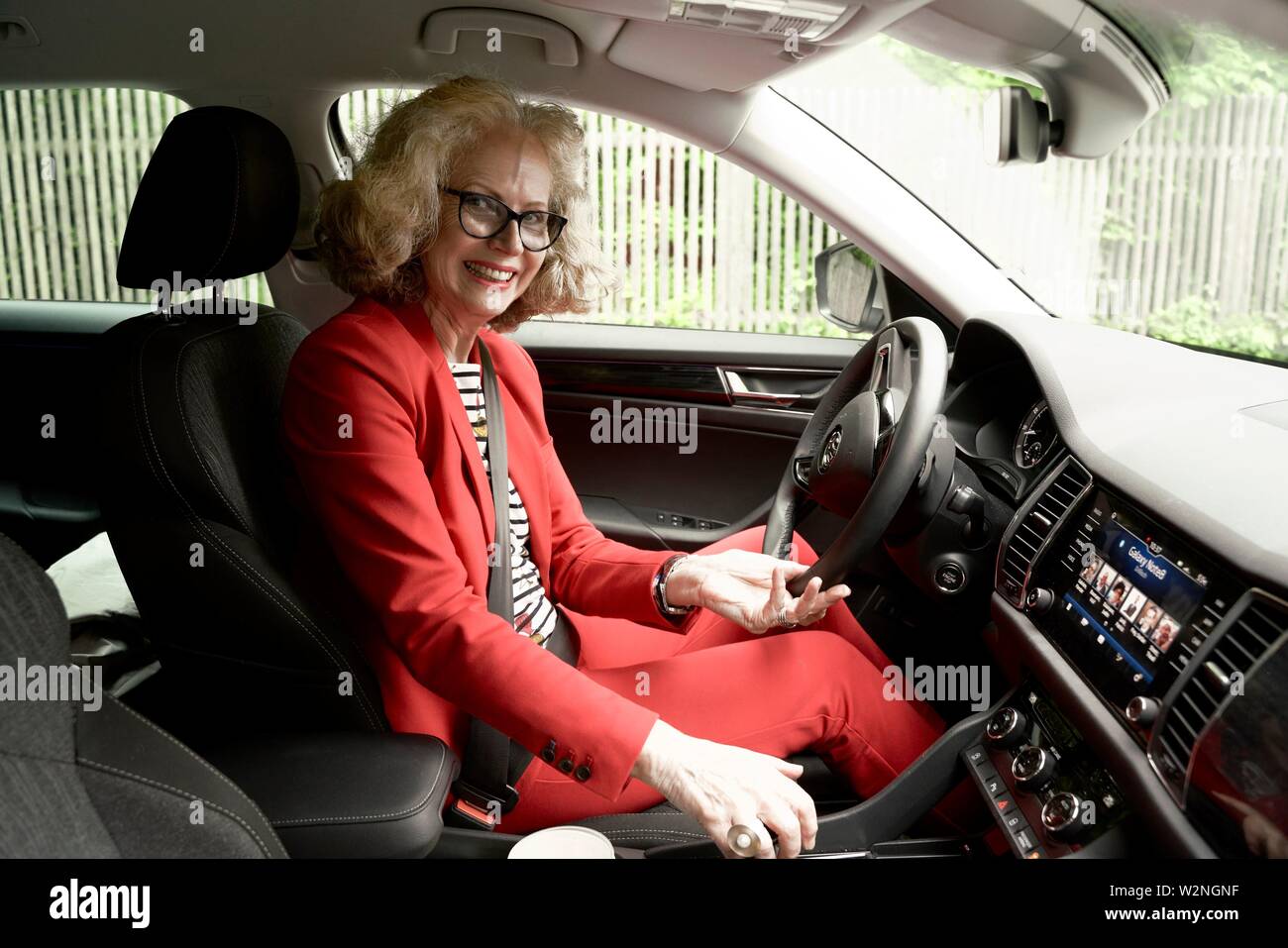 senior woman (67 years old) in car on drivers seat, in Munich, Germany