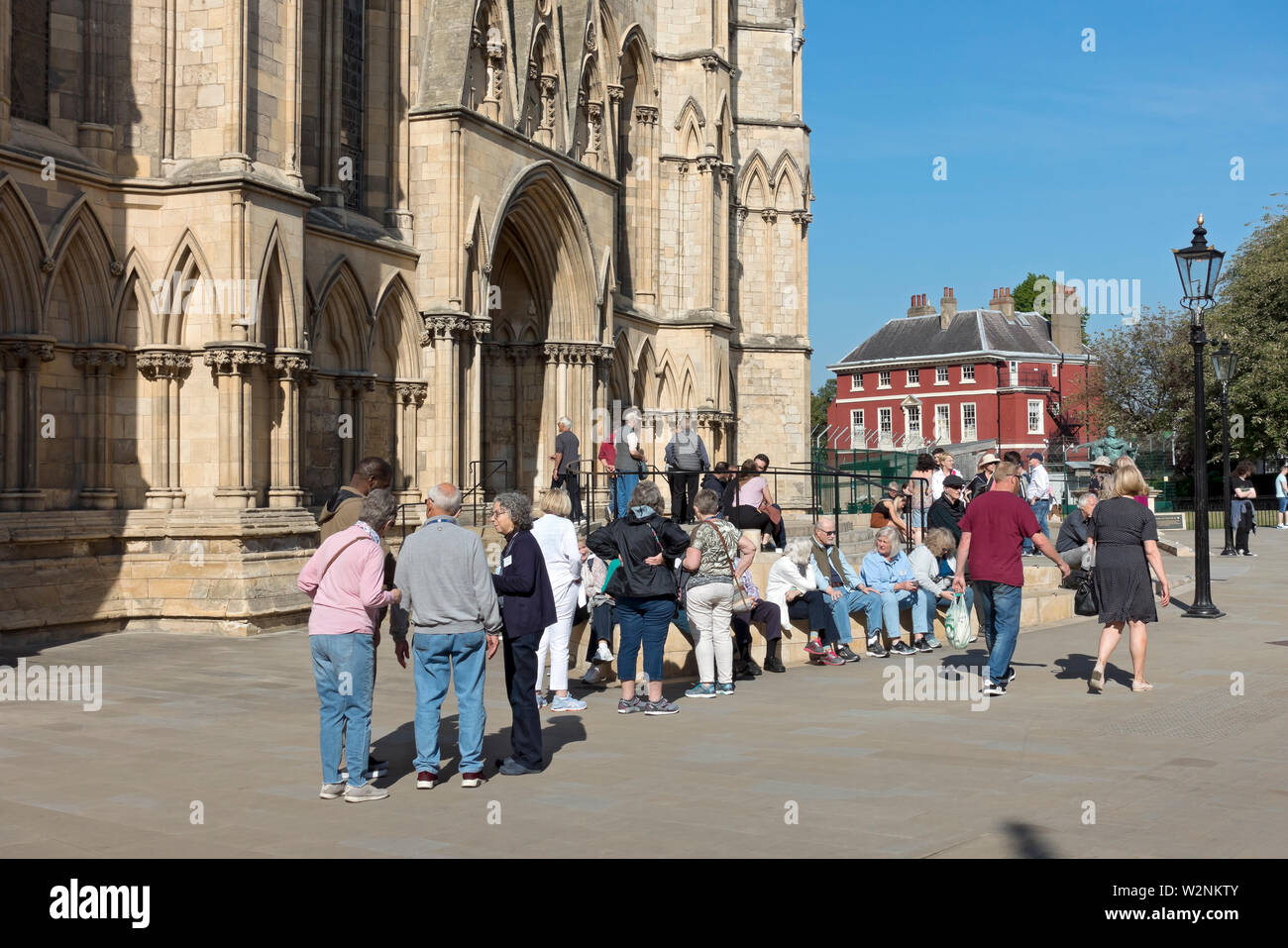 Tourists people visitors outside the South Transept of the Minster in spring York North Yorkshire England UK United Kingdom GB Great Britain Stock Photo
