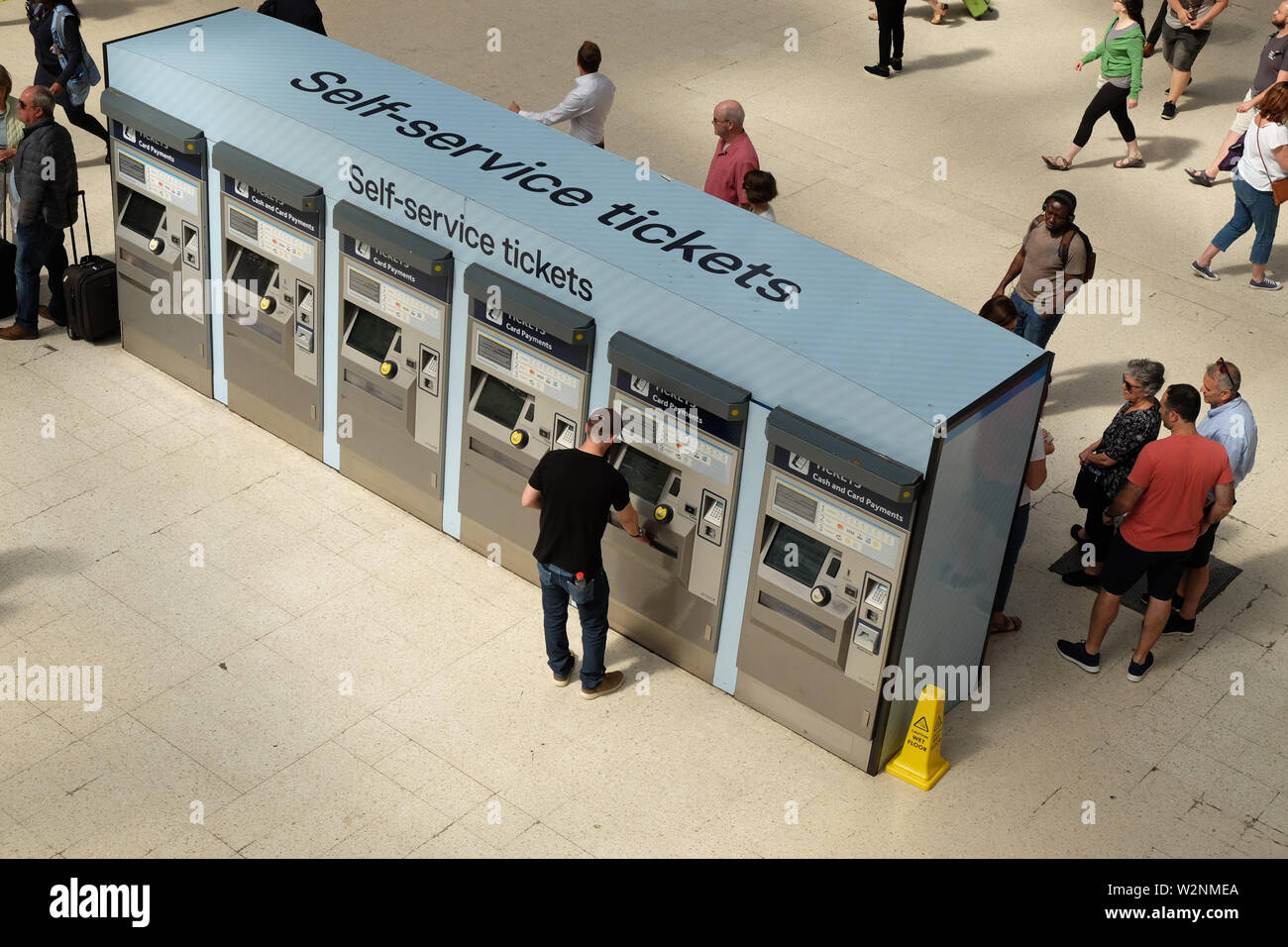 London, United Kingdom: July 1st 2019 - Passenger buying tickets at railway station using self service ticket machine Stock Photo