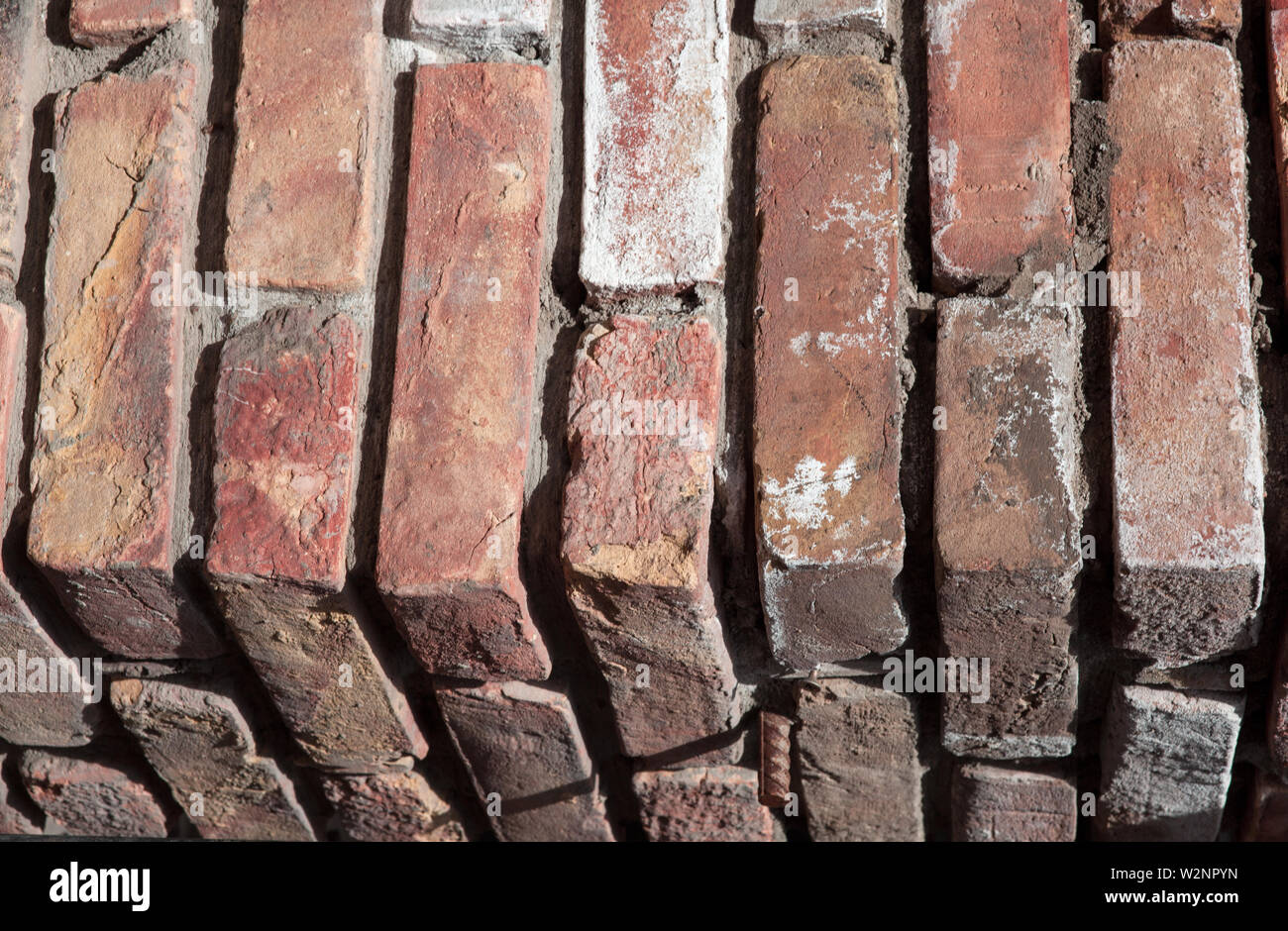 Abstraction The texture of the natural old corner of a brick wall red colored background. Stock Photo