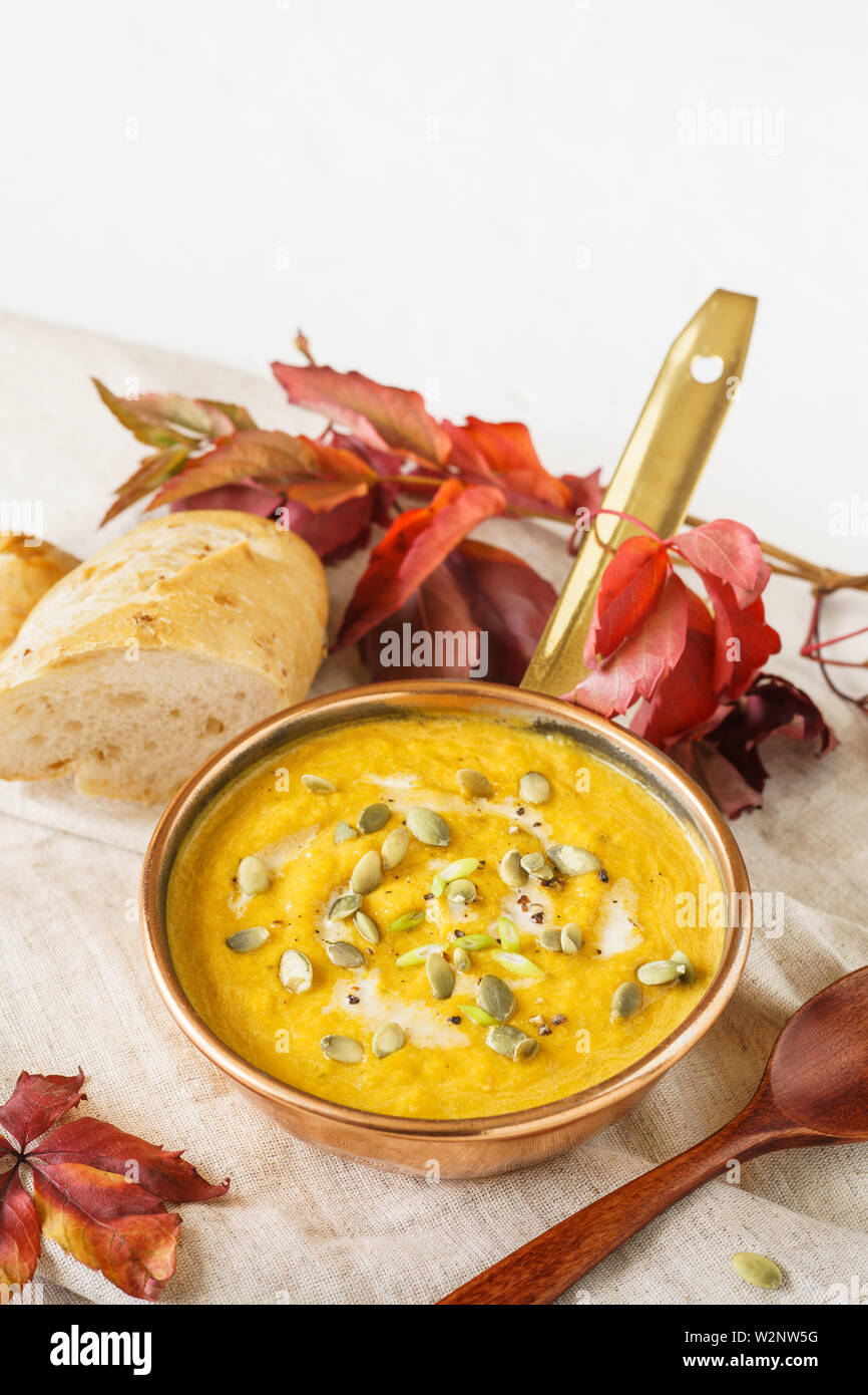 Pumpkin soup with seeds and cream for lunch. Healthy autumn food concept with copyspace. Stock Photo