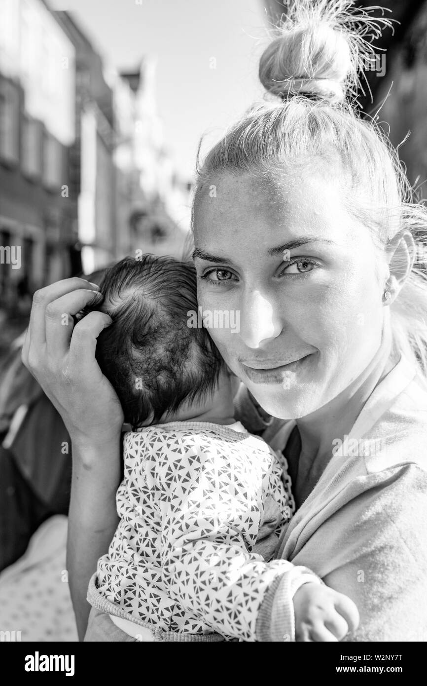Poznan / Poland - Loving mother - romanian girl hugging her child. Old town. Stock Photo