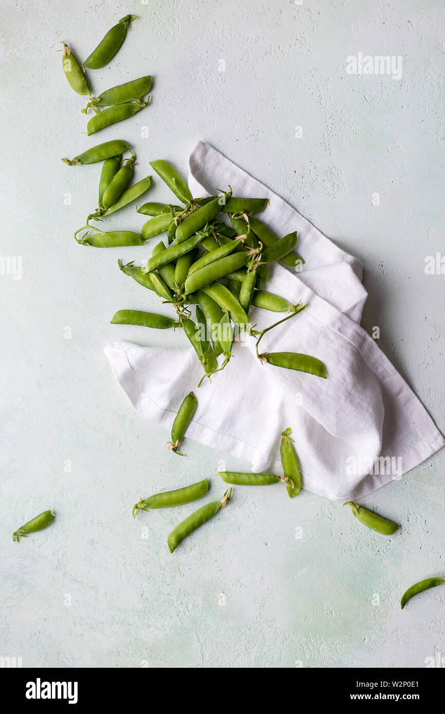 Raw green pea in concrete background with white towel. Concept of fresh harvest food Stock Photo