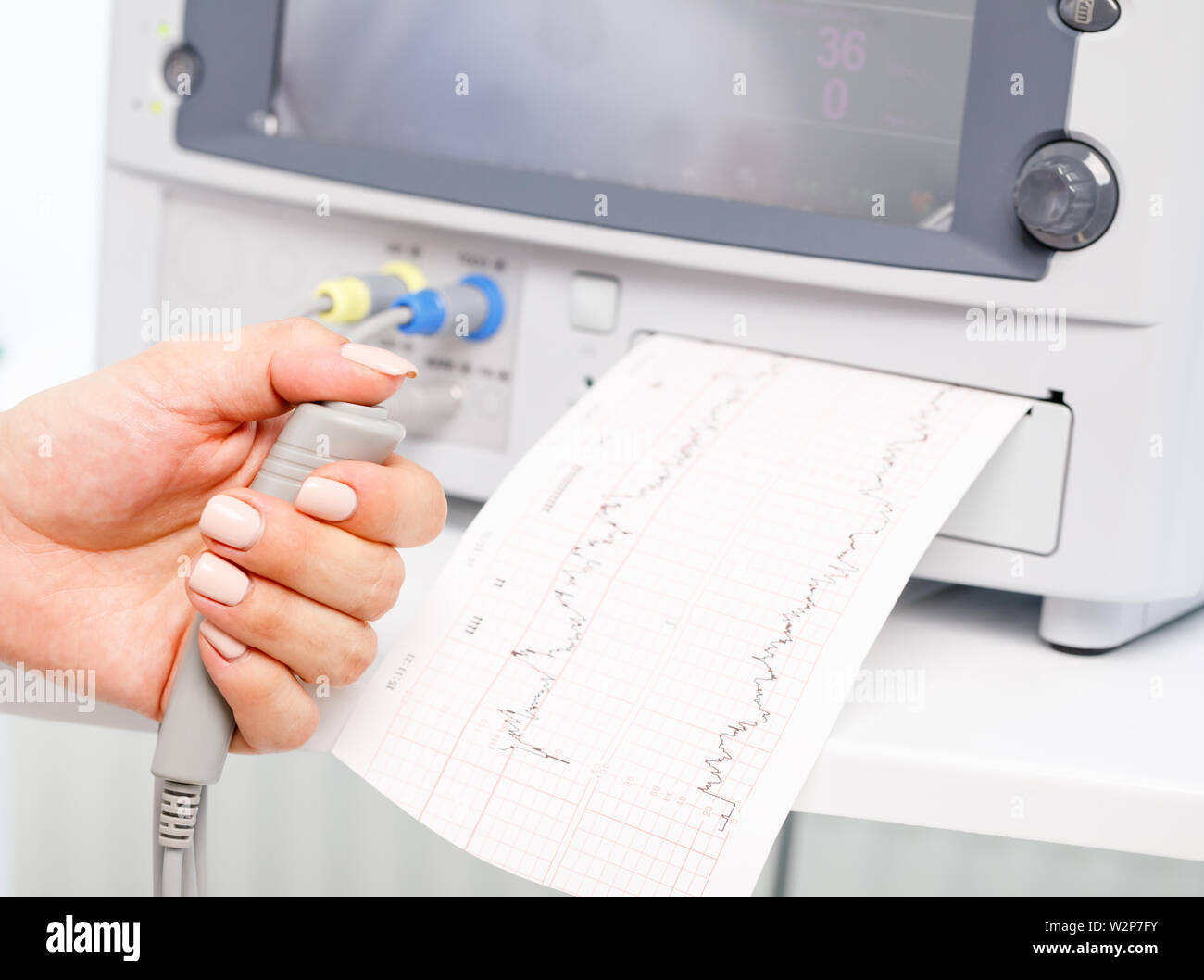 Close-up shot of pregnant woman's hand holding controller of the ...