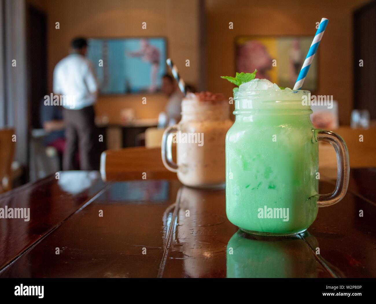 Closeup of a tasty mint-flavored green Thai milk tea on a table at a cafe with a blurred background Stock Photo