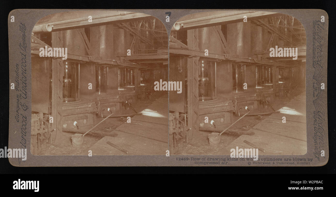 Row of drawing kilns on which cylinders are blown by compressed air.; Underwood & Underwood Stereographs of Manufacturing Industries,  Set 2 - Making glass sheets from cylinders,  Image 7 - Row of drawing kilns on which cylinders are blown by compressed air.  These stereographs were created and sold as a set for educational use by Underwood & Underwood, a maker of stereoscopic images and equipment. This set was produced between 1895, when the educational unit was established, and 1921, when the company was sold. Stock Photo