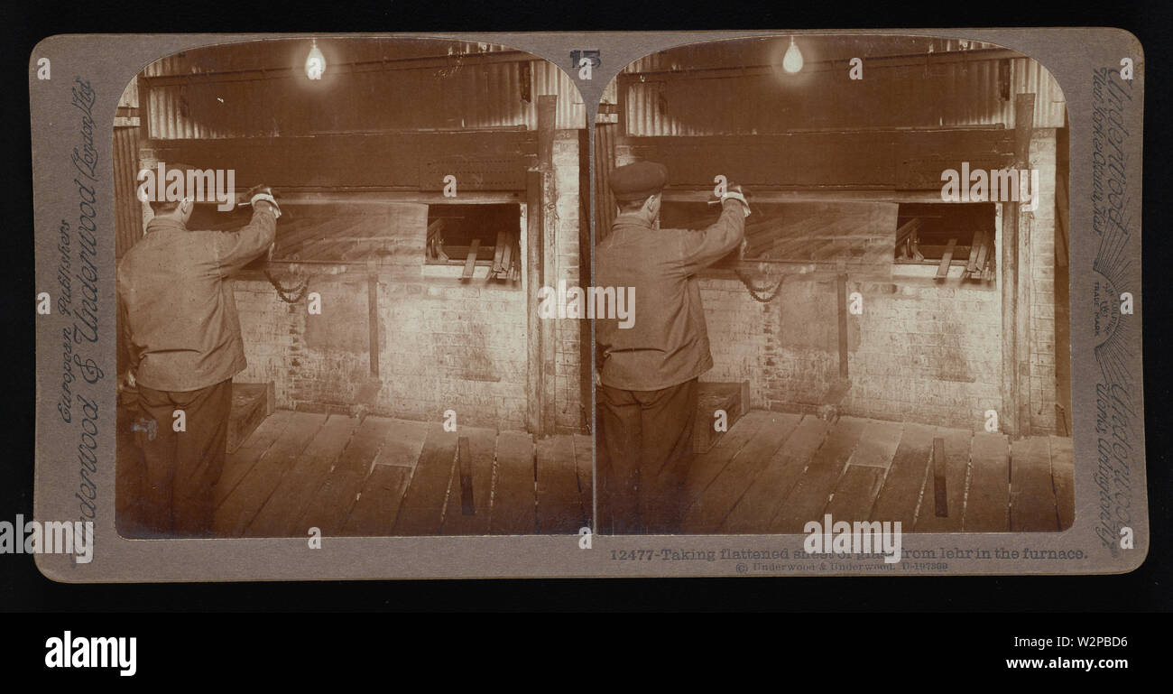 Taking flattened sheet of glass from lehr in the furnace.; Underwood & Underwood Stereographs of Manufacturing Industries,  Set 2 - Making glass sheets from cylinders,  Image 13 - Taking flattened sheet of glass from lehr in the furnace.  These stereographs were created and sold as a set for educational use by Underwood & Underwood, a maker of stereoscopic images and equipment. This set was produced between 1895, when the educational unit was established, and 1921, when the company was sold. Stock Photo