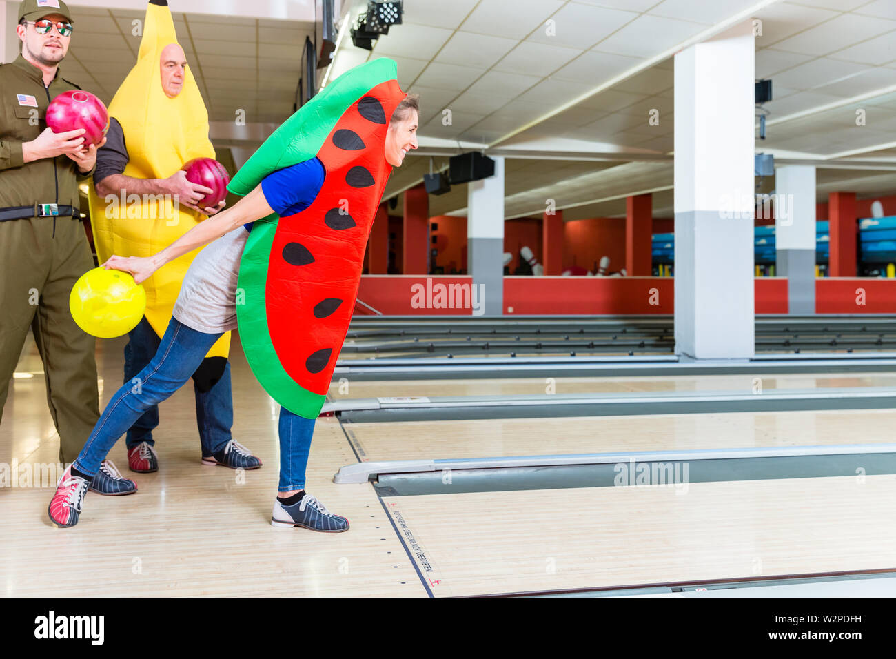 Woman in fancy clothing bowling Stock Photo
