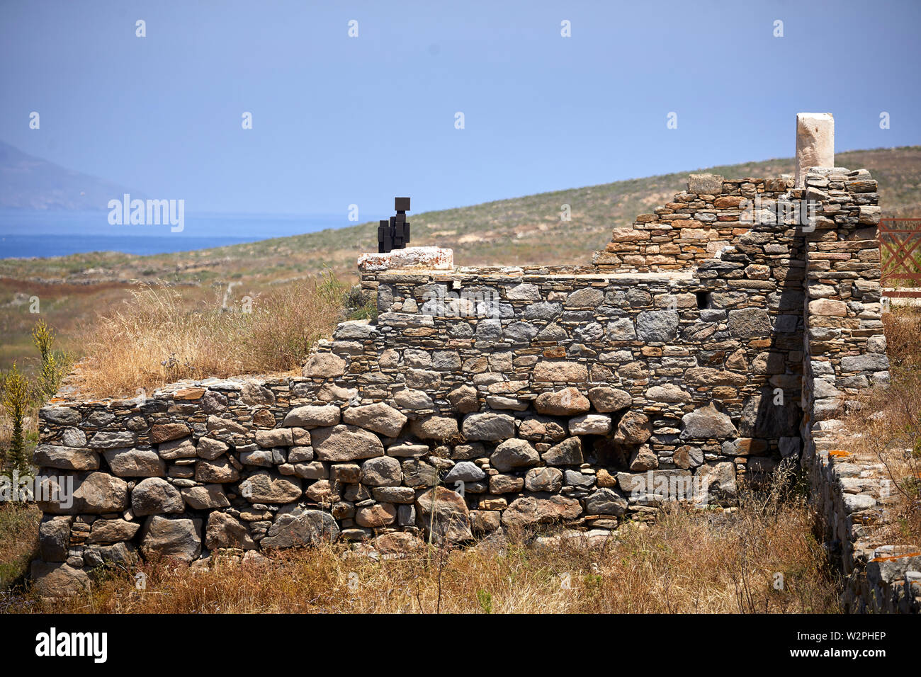 Greek, Greece, Delos historical site island, archaeological ruins with Antony Gormley statues Another Shore 2012 cubic sat  looking out Stock Photo