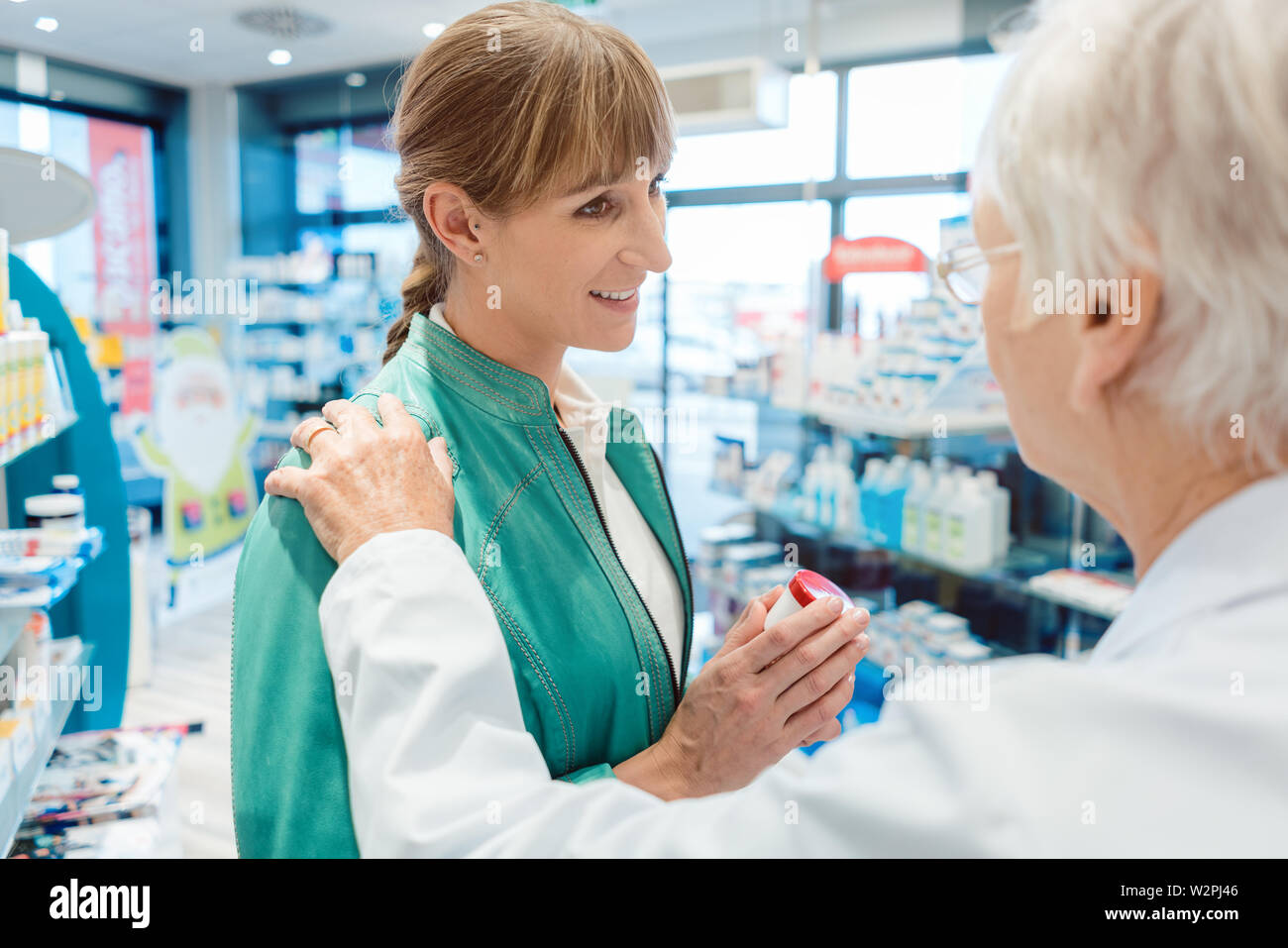 Woman customer in pharmacy buying drug hoping to get better Stock Photo