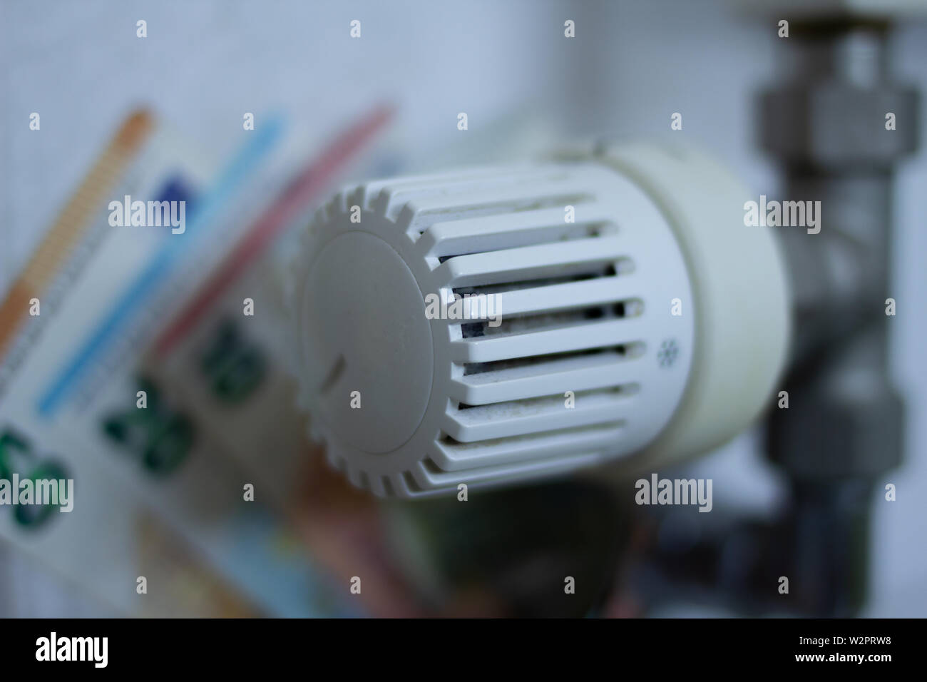 Close up Thermostat with euro currency banknotes in the Background. Energy Price increase. Household Budget planning. Green energy Stock Photo