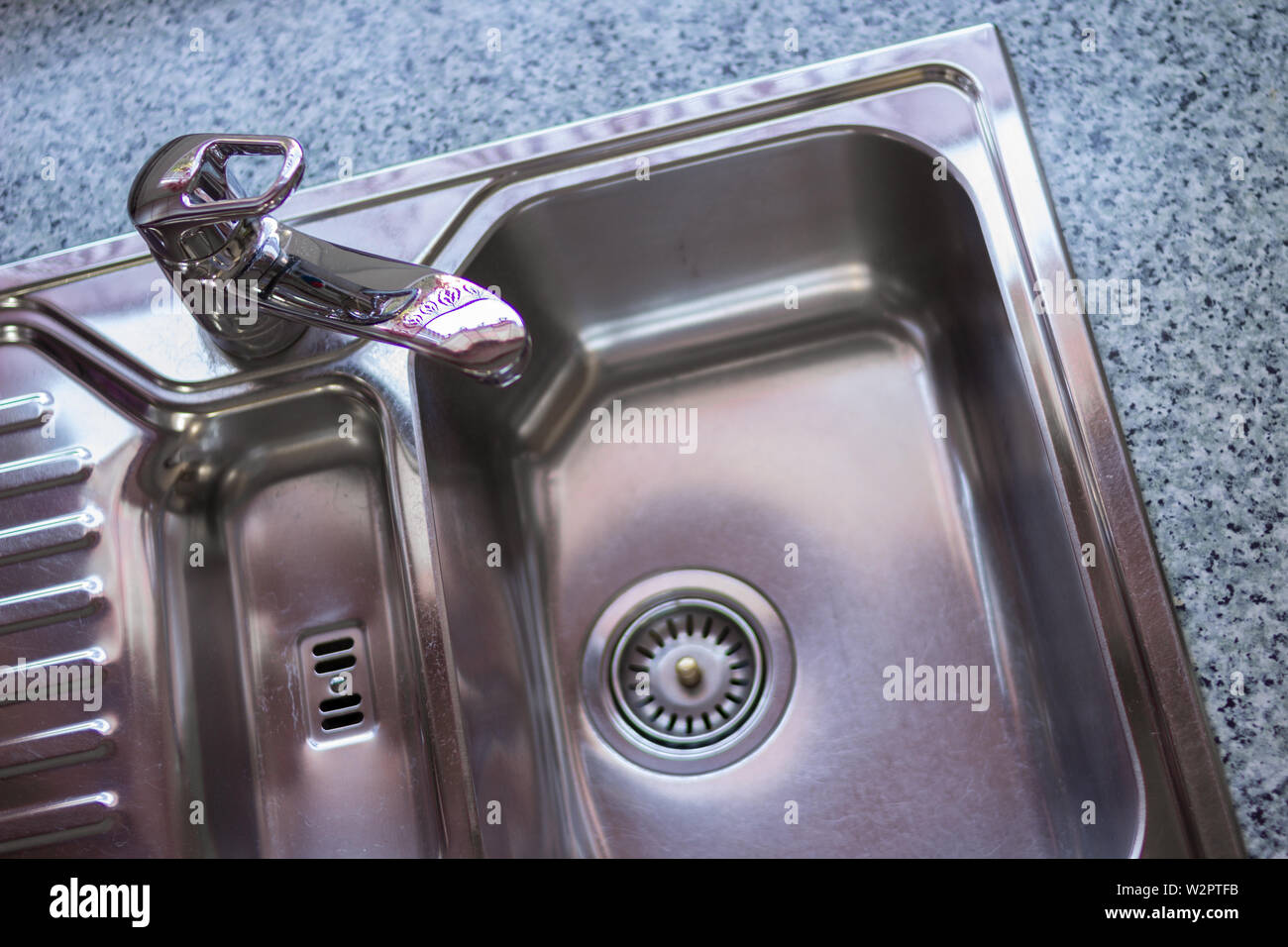 Kitchen sink Concept. Clean Chrome sink in a modern kitchen with copy
