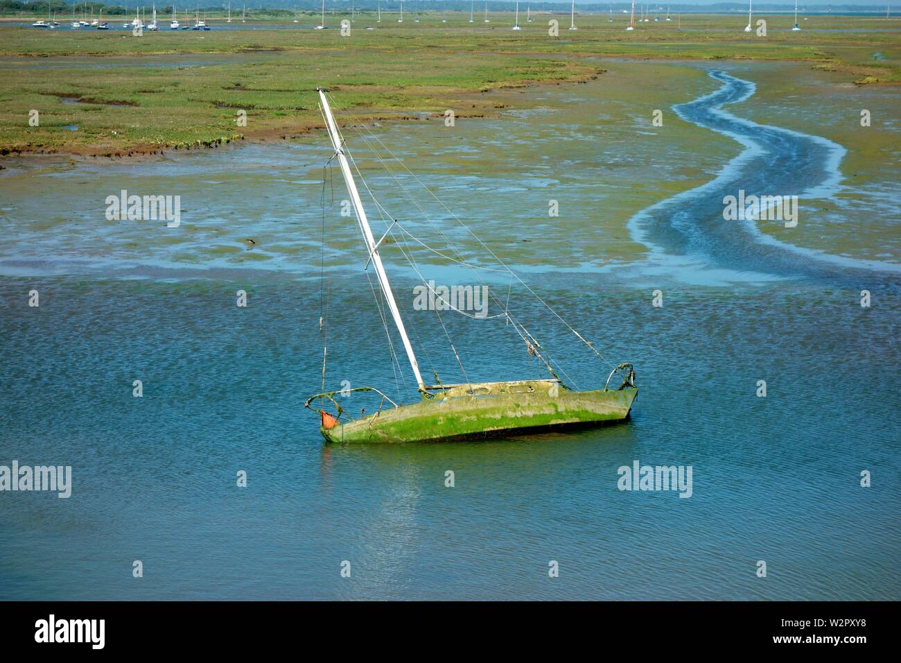 A sinking yacht  abandoned in mudflats outside Keyhaven Stock Photo