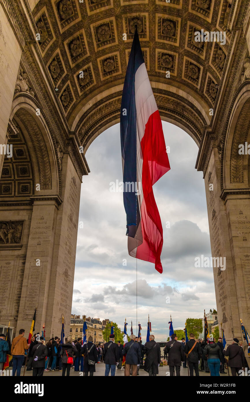 At the base of the Arc de Triomphe in Paris during the rekindling of the torch, while veterans lay wreaths to recall the sacrifice of an unknown... Stock Photo