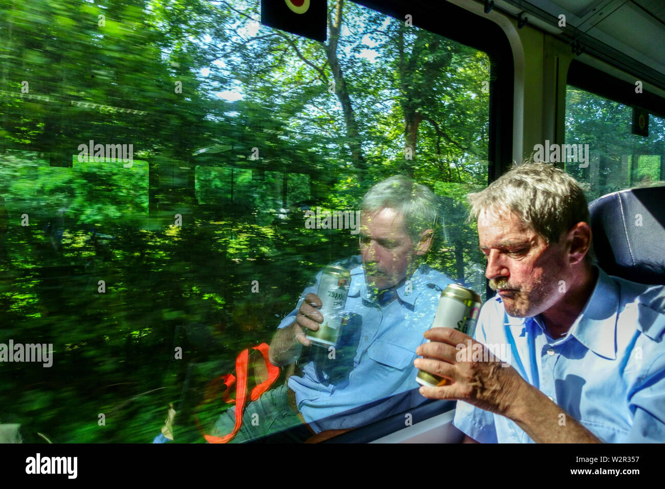 Train window, A passenger on the train is drinking beer from a can, regional train Germany Europe German tourist train Stock Photo